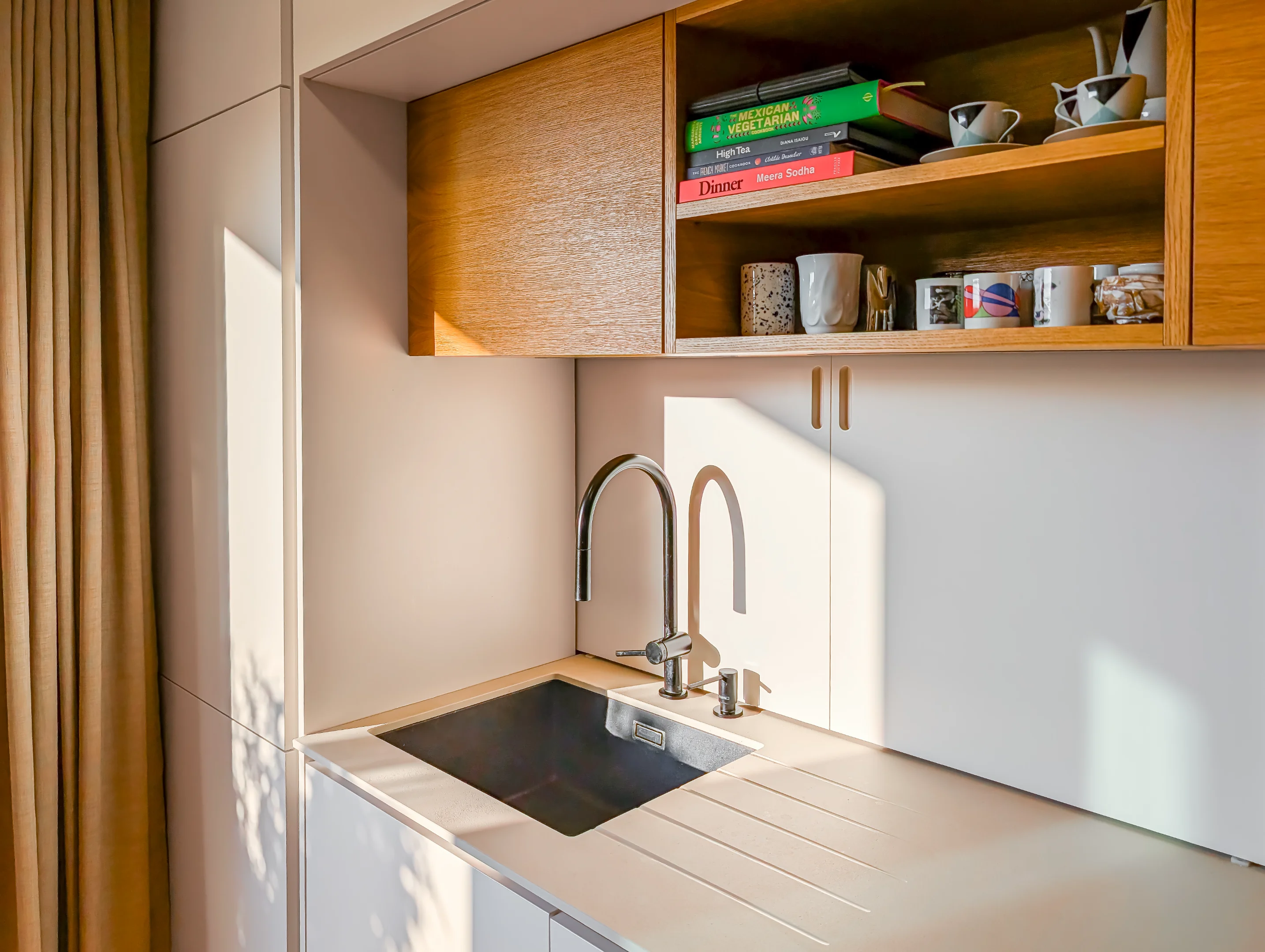 Moderní kuchyňská linka s dřevěnými prvky a nerezovým dřezem.